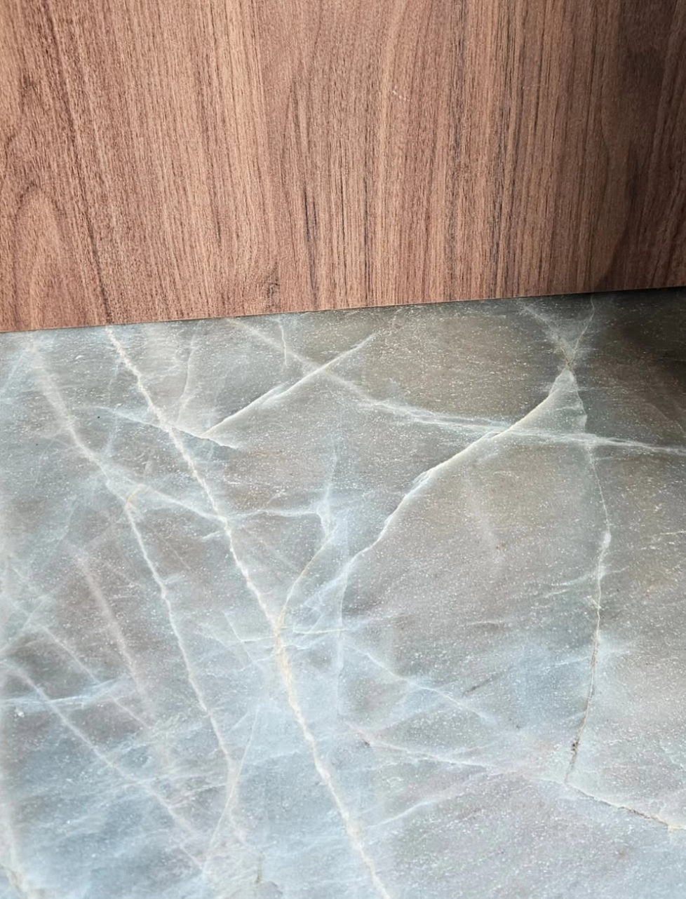 Plan de travail en quartzite associé à des façades de cuisine en noyer sur mesure.